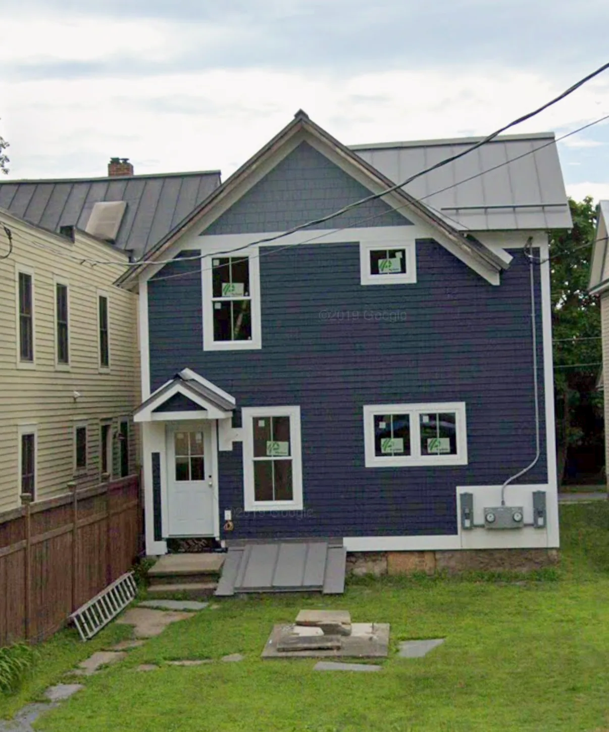 Standing seam metal roof on a navy clapboard home