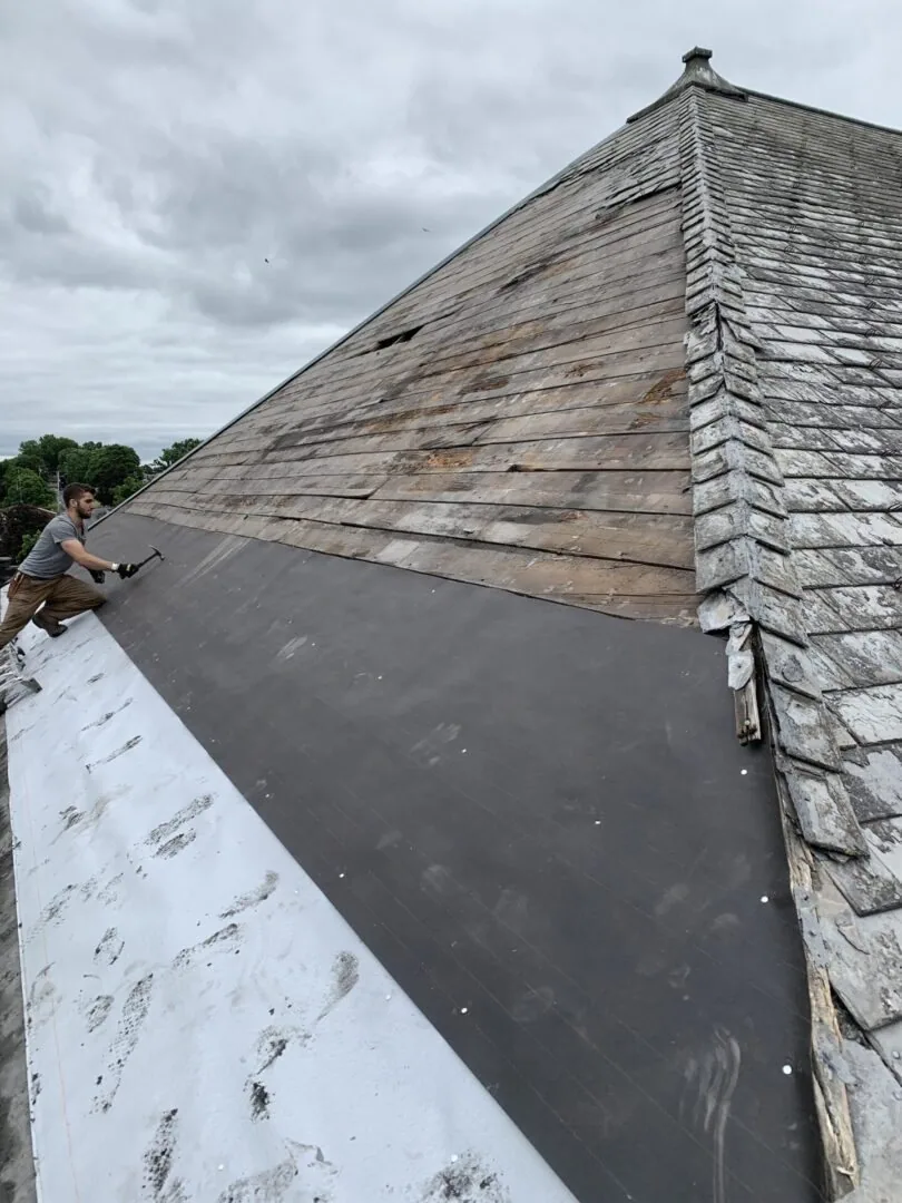 Roofer carrying out repair work on a residential roof
