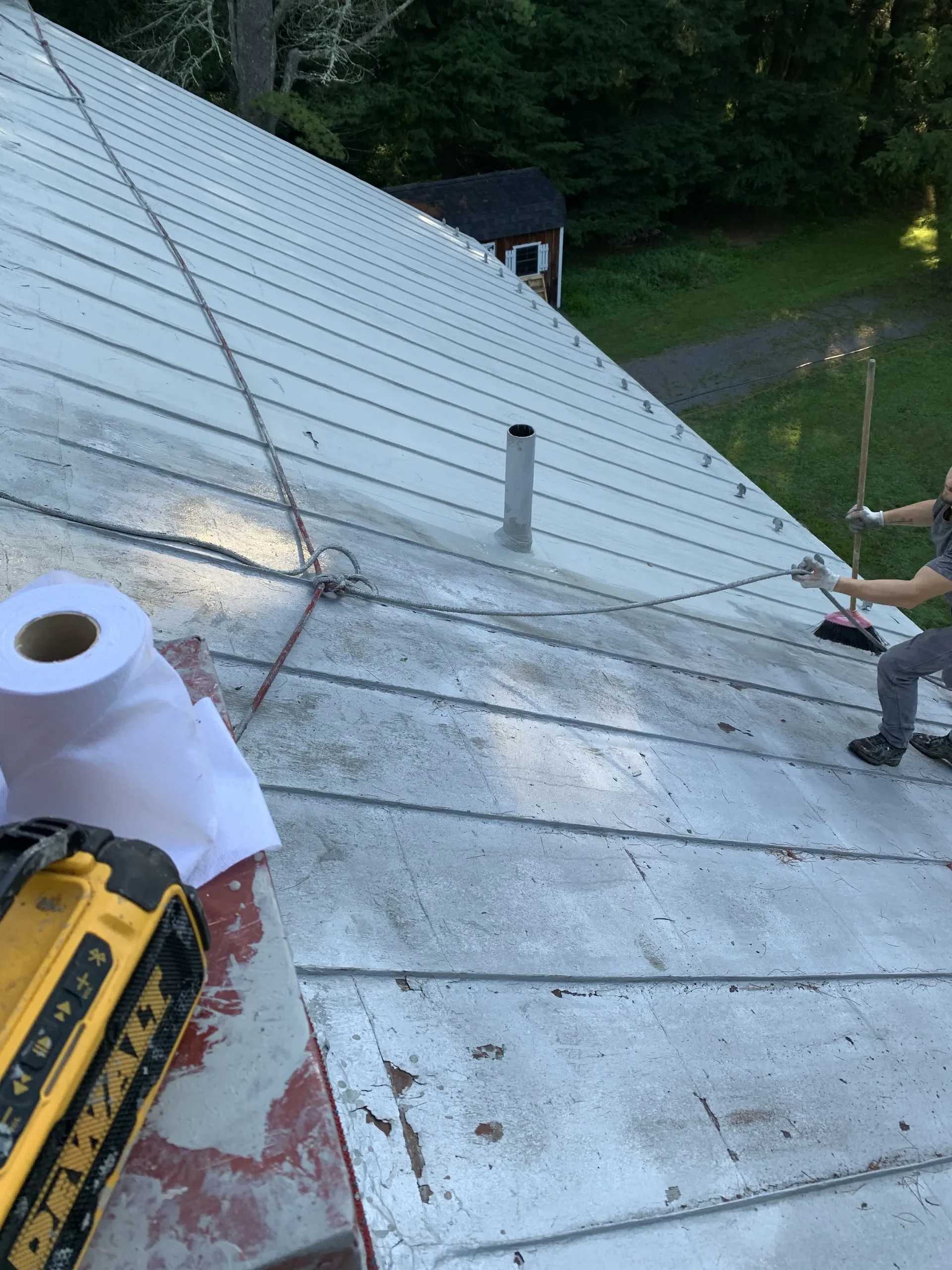 Roof coating being applied on a low-slope roof