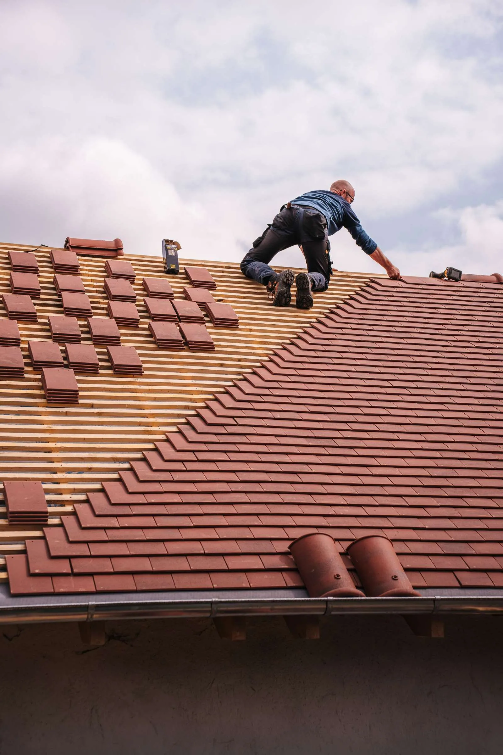 Roofer replacing damaged roofing material on a residential roof