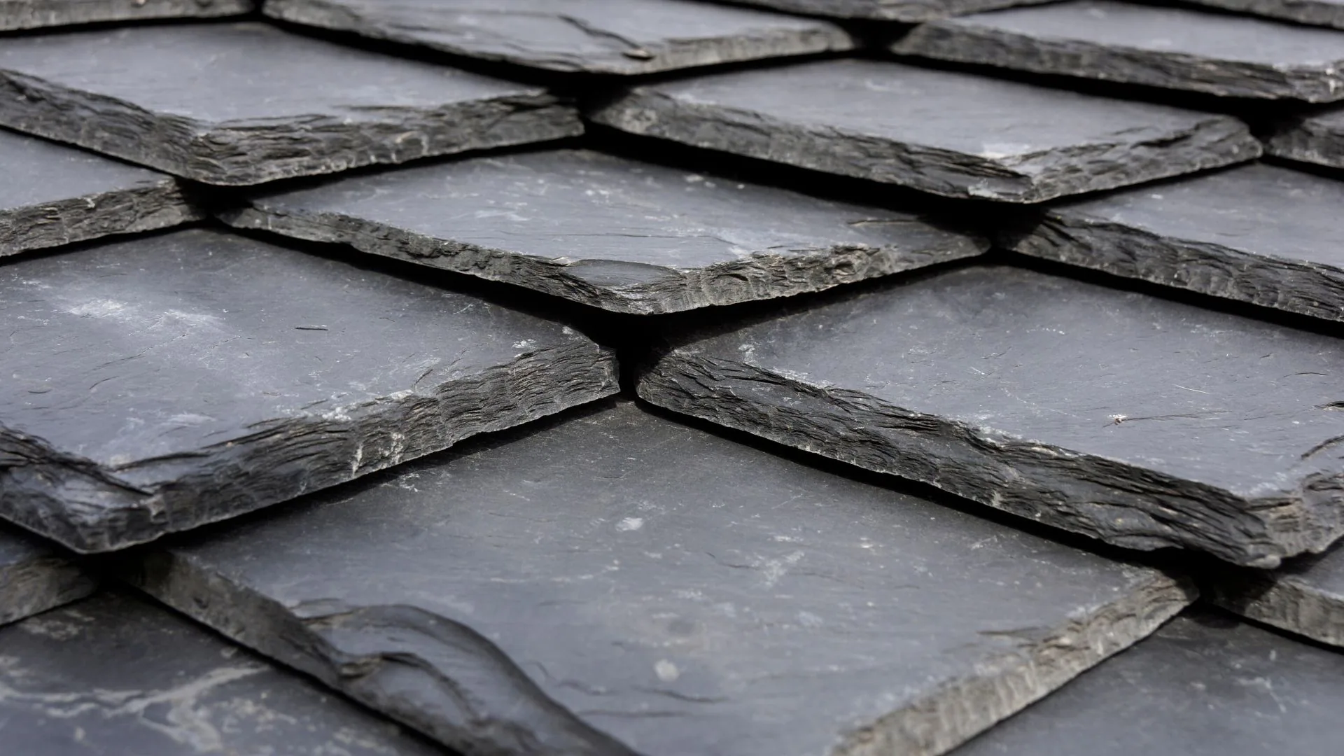 Slate tiles being repaired and refitted on a roof